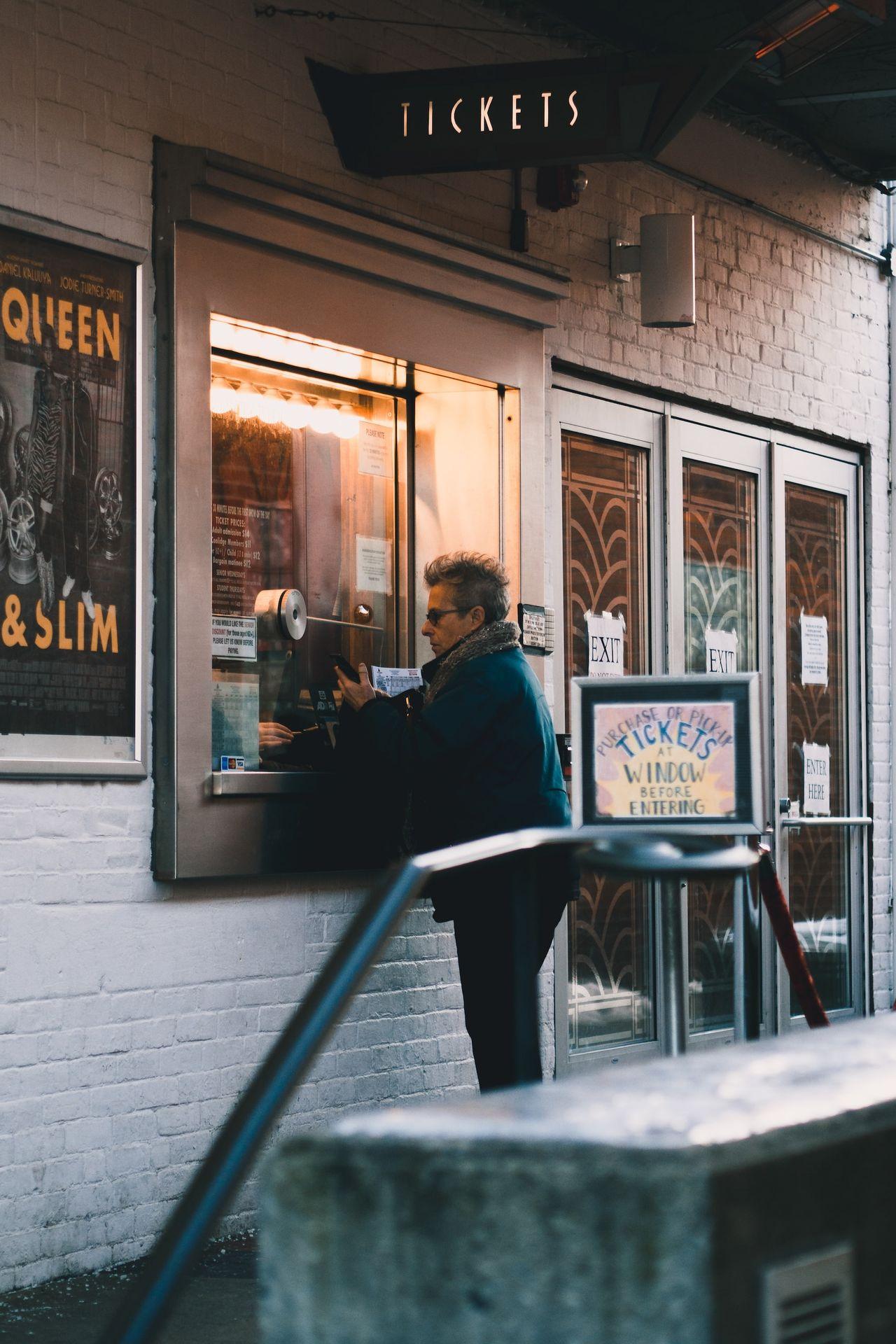 man in black jacket sitting on chair in front of store