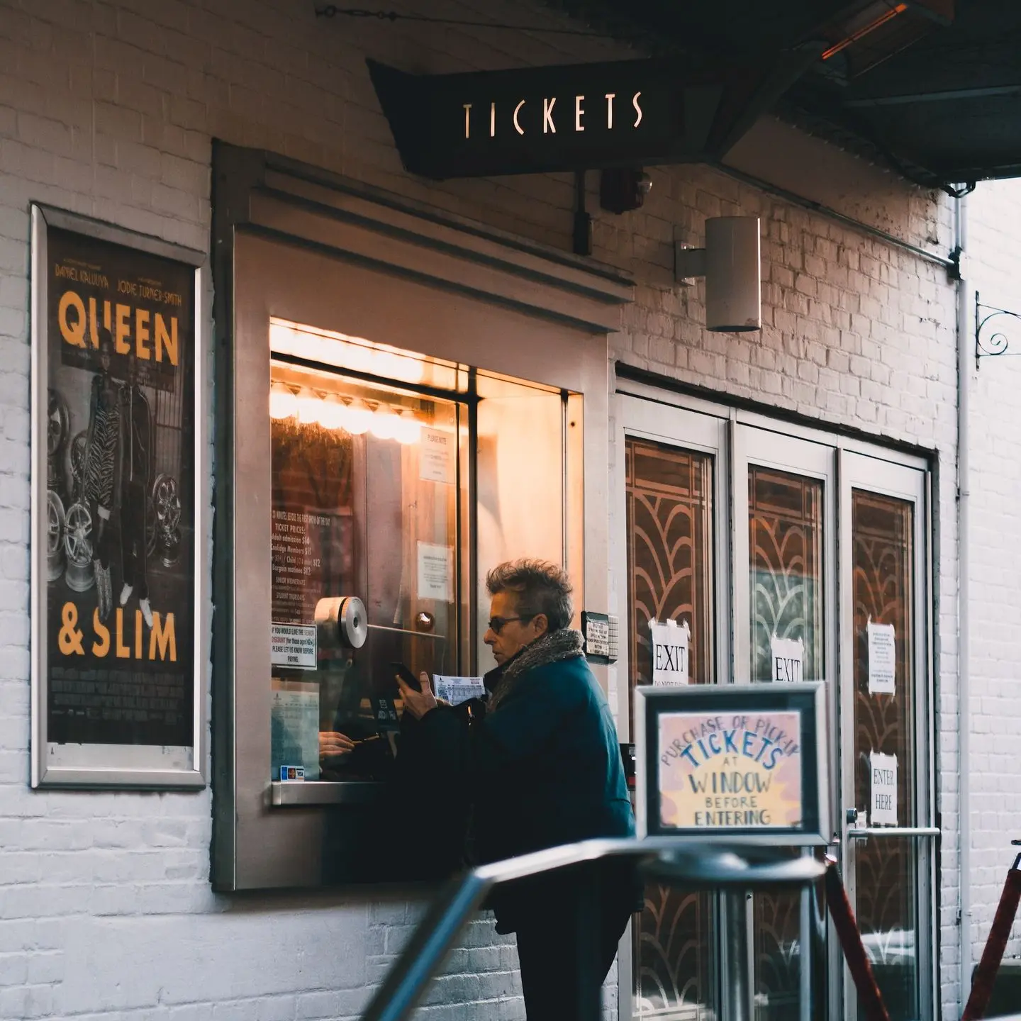 man in black jacket sitting on chair in front of store