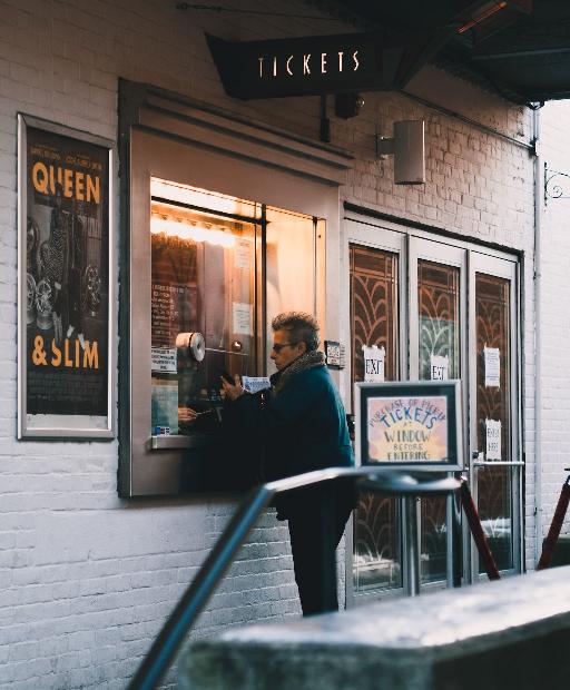man in black jacket sitting on chair in front of store